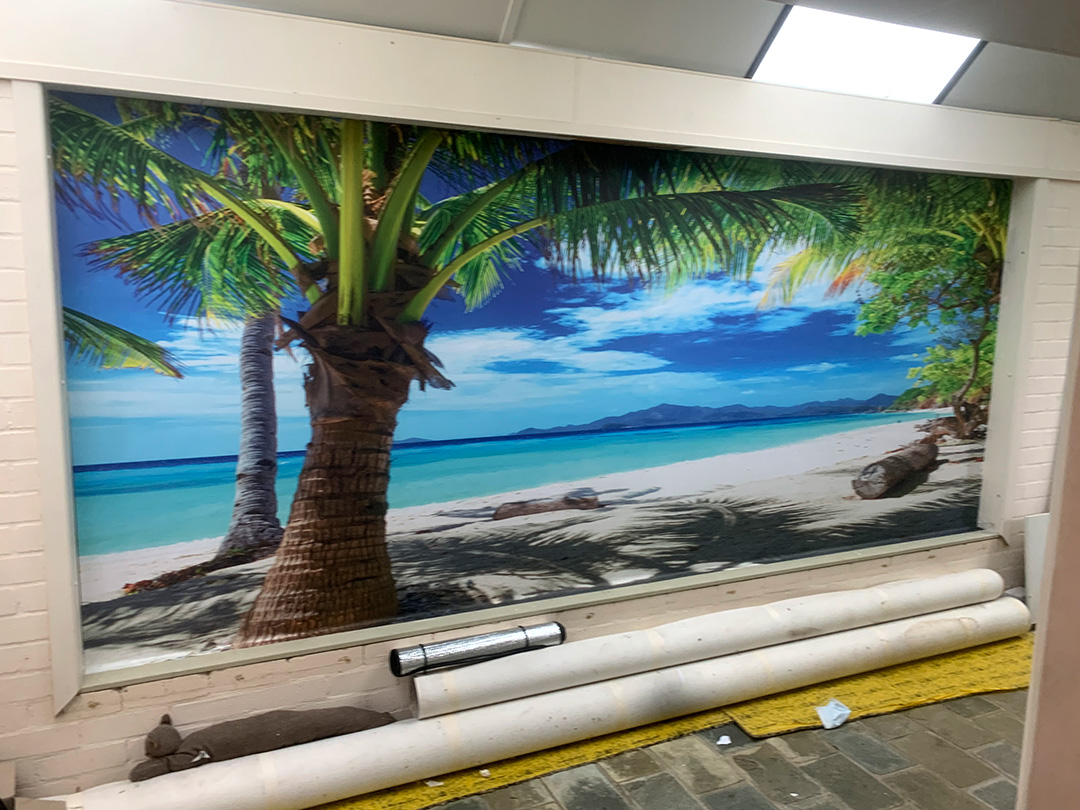 A large wall mural depicts a beach scene.